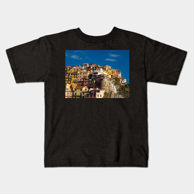 View on the cliff town of Manarola, one of the colorful Cinque Terre on the Italian west coast Kids T-Shirt by Dolfilms